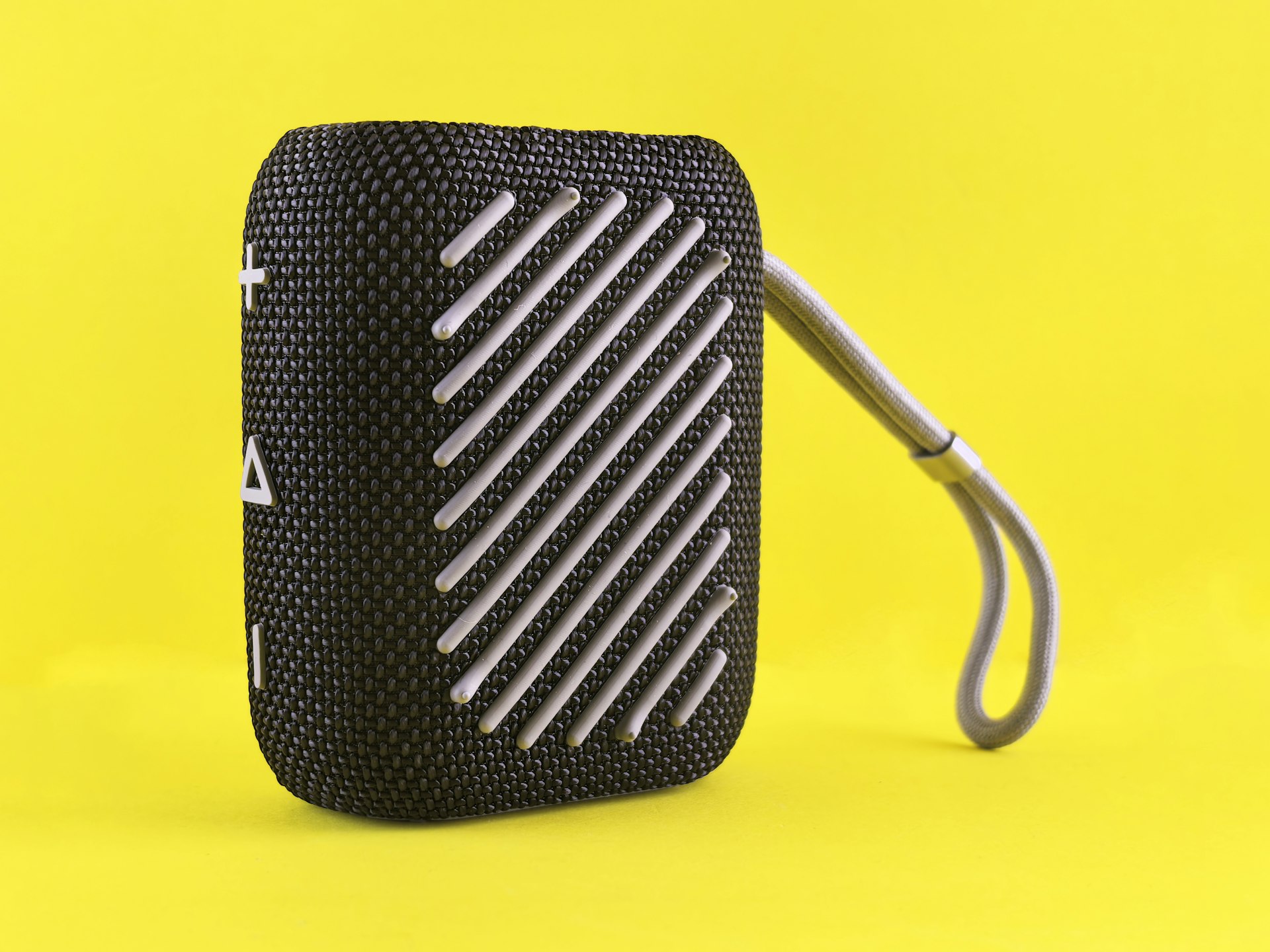 Black portable speaker with grey strap on yellow background